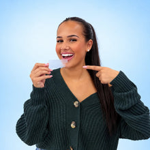 Model holding Smileey PAP+ teeth whitening strip sachets on a light blue background